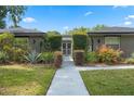 Close-up view of the home's charming walkway with a gated entry, complemented by lush landscaping at 4118 Teriwood Ave, Orlando, FL 32812