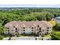 Wide aerial view of a condo building with lush surrounding greenery and ample parking at 422 Terrace Ridge Cir # 422, Davenport, FL 33896