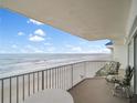 Relaxing balcony with seating overlooking the beach, perfect for enjoying ocean breezes at 4601 S Atlantic Ave # 7030, Port Orange, FL 32127