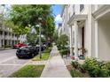 Street scene with beautiful townhomes, well-kept sidewalks, and lush green landscaping at 4725 Anson Ln, Orlando, FL 32814