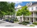 Attractive townhomes line a street with mature trees and parked cars, creating a vibrant neighborhood scene at 4725 Anson Ln, Orlando, FL 32814