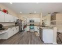 Open kitchen with white cabinets, granite countertops, stainless steel appliances, and durable laminate floors at 502 Freeman St, Longwood, FL 32750
