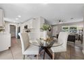 Open concept dining area with a glass table and white chairs adjacent to a modern kitchen and cozy living room at 507 Peach Tree Ln, Altamonte Springs, FL 32701