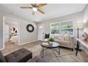 Bright living room with neutral tones, a ceiling fan, and an eye-catching rug, creating a welcoming space at 507 Peach Tree Ln, Altamonte Springs, FL 32701