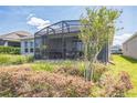 Spacious backyard with screened-in lanai, perfect for outdoor living and entertaining at 525 Narrow View Ln, Groveland, FL 34736