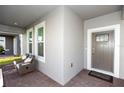 Cozy front porch with comfortable seating, a brick floor, and an exterior front door at 635 Cheval Ln, Debary, FL 32713