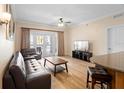 Comfortable living room with wood floors and a view to the outdoor balcony at 7689 Heritage Crossing Way # 202, Reunion, FL 34747