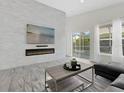 Bright living room with a modern fireplace, and views of the backyard pool at 833 Lockbreeze Dr, Davenport, FL 33897