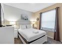 Bright bedroom with a queen bed, white linens, two side tables, and a window with blinds at 8804 Rhodes Street, Kissimmee, FL 34747