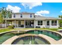 Beautiful backyard with a screened-in patio, lush landscaping, and a custom pool with a water feature at 955 Holly Springs Ter, Oviedo, FL 32765