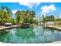 Backyard boasts a beautiful stone pool with lush landscaping and a rock feature at 955 Holly Springs Ter, Oviedo, FL 32765