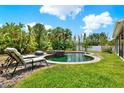 Inviting backyard featuring a sparkling pool, lush landscaping, and comfortable lounge chairs at 955 Holly Springs Ter, Oviedo, FL 32765