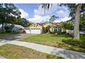 Beautiful single-story home featuring a three-car garage, mature trees, and a well-manicured lawn at 1006 Hanging Vine Pt, Longwood, FL 32750