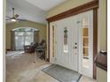 Inviting foyer with a tiled floor, decorative front door, and views into the living room at 1006 Hanging Vine Pt, Longwood, FL 32750