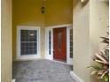 Welcoming front entrance featuring a red door, sidelights, and brick-paved porch at 1006 Hanging Vine Pt, Longwood, FL 32750