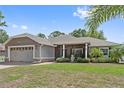 Lovely house with a well-kept lawn, landscaping, and a charming screened porch at 12137 Buttonbush Loop, Leesburg, FL 34788