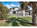 Front lawn view of the charming white home with a two-car garage and a lamp post on the lawn at 181 Pinewood Cir, Kissimmee, FL 34743