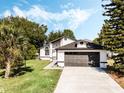 Single-story home with a well-manicured lawn, mature trees, and a convenient two-car garage at 181 Pinewood Cir, Kissimmee, FL 34743