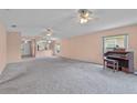 Open-concept living room featuring plush carpeting, view of kitchen, and a classic organ at 2244 Silver Lakes N Dr, Lakeland, FL 33810
