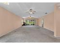 Spacious living room with plush carpeting, ceiling fans, and large sliding doors with a water view at 2244 Silver Lakes N Dr, Lakeland, FL 33810