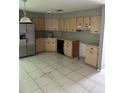 Kitchen featuring tiled flooring, plenty of cabinet space, and stainless-steel refrigerator at 2342 Cilantro Dr, Orlando, FL 32837