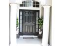 Home entryway with black front door framed by columns and potted plants at 2407 Oakington St, Winter Garden, FL 34787