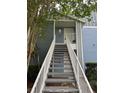 View of the entrance stairs to unit 210 with blue siding and white railings at 2516 Grassy Point Dr # 210, Lake Mary, FL 32746