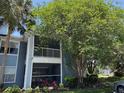 Exterior view of a condominium building with screened balconies and lush landscaping at 2516 Grassy Point Dr # 210, Lake Mary, FL 32746