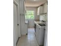Functional laundry room featuring a window, white cabinets, and a full-size washer and dryer at 261 Deleon Rd, Debary, FL 32713