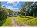Charming white home with a lush green yard and a palm tree, creating a serene and welcoming ambiance at 2647 S Myrtle Ave, Sanford, FL 32773