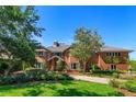 Two-story red brick home featuring lush landscaping, mature trees and a front lawn at 2828 Marquesas Ct, Windermere, FL 34786
