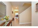 Hallway features tile flooring, stairway, decor, with a view of the dining room at the end at 2919 Banana Palm Dr, Kissimmee, FL 34747