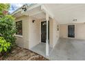 Close-up showcases the covered carport area of the house, featuring a dark front door and overhead lighting at 3025 Bon Air Dr, Orlando, FL 32818