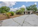 View of a single-story home featuring a long driveway leading to a covered carport with dual entry doors at 3025 Bon Air Dr, Orlando, FL 32818