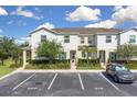 Inviting townhome showcasing manicured landscaping, parking, and a cozy entrance, set against a bright, cloudy sky at 320 Primrose Dr, Davenport, FL 33837