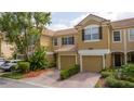 Charming townhome featuring a brick driveway, tile roof, and lush landscaping at 3567 Shallot Dr # 103, Orlando, FL 32835