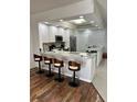 Bright kitchen with granite countertops, stainless steel appliances, barstool seating, and modern lighting at 3567 Shallot Dr # 103, Orlando, FL 32835