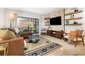 Sunlit living room with a large sliding glass door, plush leather sofa, and stylish decor at 4332 Lake Underhill Rd # 12D10, Orlando, FL 32803