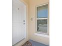 Close-up of the front door with a smart lock, doorbell, and welcome mat at 4725 Coral Castle Dr, Kissimmee, FL 34746
