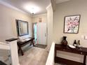 Inviting foyer featuring a decorative mirror, dark wood accent tables, and a welcoming front door at 5114 Hawkstone Dr, Sanford, FL 32771