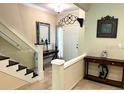 Inviting foyer showcasing staircase, tiled flooring, elegant decor, and a well-lit entry at 5114 Hawkstone Dr, Sanford, FL 32771