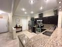 Well-lit kitchen featuring granite countertops, stainless steel appliances, and dark wood cabinetry at 5114 Hawkstone Dr, Sanford, FL 32771