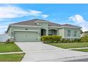 Well-manicured one-story home boasts lush landscaping, a two-car garage, and a welcoming driveway at 5393 Red Coral Cir, Mount Dora, FL 32757