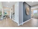 Hallway featuring wood floors, a large decorative wall hanging, and views of the dining and living areas at 6009 Tree Crossing Ln, St Cloud, FL 34771