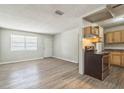 Bright living area with laminate floors and a front door, adjoins an eat-in kitchen with light-toned wooden cabinetry at 6042 Bolling Dr, Orlando, FL 32808