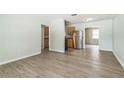 Spacious living room featuring modern wood-look flooring and neutral paint, leading to an open kitchen area at 6042 Bolling Dr, Orlando, FL 32808