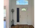 Bright entryway with wood floors, coat rack, and a white front door with transom window at 6730 Orlando Drive, Indian Lake Estates, FL 33855