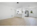 Bright and open living room with modern wood-look floors adjacent to the white kitchen at 6820 Ambassador Dr, Orlando, FL 32818