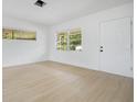 Bright living area with wood-look flooring, a large window, and white walls at 6820 Ambassador Dr, Orlando, FL 32818