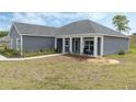 A single-story home featuring modern architecture, a manicured lawn and a welcoming front porch at 72 Fairway Cir, Umatilla, FL 32784